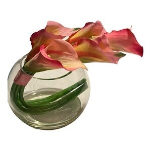 Pink calla lilies in clear round vase in resin.